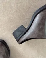 Zueco de cuero negro con punta redondeada y taco cuadrado de 4.5 cm. Diseño tipo mule con plantilla acolchada y marca Lucy in the Sky.