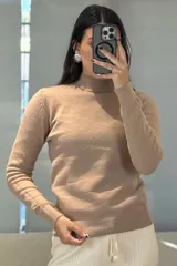 Buzo de tejido de punto color rosa, con cuello alto y puños acanalados.