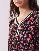 Conjunto de pijama de short y remera en tejido soft estampado. Remera de escote en V con aplique de puntilla, botones y detalle plisado. Short con cintura elastizada.