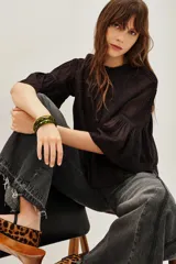 Camisa de algodón color negro, con cuello redondo, mangas tres cuartos abullonadas y detalles de encaje y alforzas en el frente y mangas.