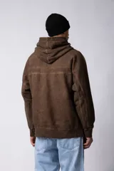 Buzo canguro de frisa gruesa con capucha, diseño oversize y acabado con efecto gastado. Presenta recortes horizontales en el frente y puños con elástico.