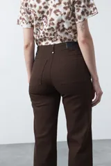 Pantalón de mujer color beige, de corte recto y tiro alto, con costuras frontales marcadas que recorren la pierna.