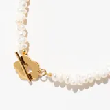 Collar corto de perlas de río con cierre de flor dorada.