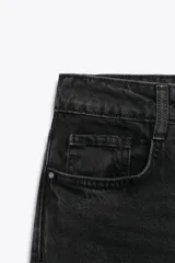 Jeans tobilleros de tiro alto, color negro lavado, con pernera recta y acabado sin costura en el ruedo. Modelo de cinco bolsillos con cierre frontal de cremallera y botón.