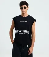 Musculosa negra de algodón con corte recto y hombros ligeramente ampliados (boxy fit). Presenta estampado frontal en blanco con el texto "URBAN SCENE TRENDS", "NEW YORK" y "Manhattan 1974".