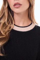 Sweater de punto color marrón con cuello redondo, puños y cuello con detalles de rayas blancas en contraste. De corte holgado y manga larga.