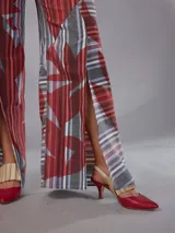Pantalón de cintura alta y piernas amplias en lino mezcla, con estampado vegetal en tonos bordó, gris y blanco, y tajos asimétricos en las piernas. Cuenta con cierre invisible lateral y bolsillos.