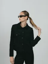 Campera verde militar de pana con cuello camisero, cierre frontal con botones a tono, dos bolsillos de parche con solapa en el pecho y corte cropped.