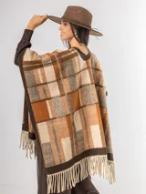 Ruana abierta con diseño de cuadros en tonos azul, beige y blanco, con terminación de flecos en el ruedo.