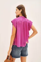 Camisa de corte amplio y mangas cortas, con cuello mao y cierre frontal de botones. Confeccionada en tejido fluido con acabado satinado.