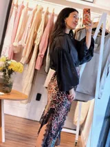 Falda asimétrica de seda con estampado animal print, talle elástico y detalle de encaje negro en el ruedo.