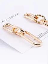 Caravanas colgantes de diseño minimalista compuestas por dos eslabones rectangulares entrelazados en tono dorado.