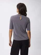 Remera de cuello redondo y manga corta, confeccionada en tejido de viscosa y poliéster, con un diseño básico y versátil.