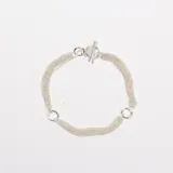 Pulsera de múltiples cadenas finas de plata, con cierre de barra en T y dos argollas circulares decorativas.