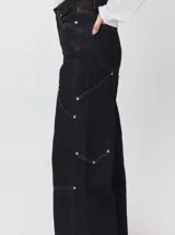 Pantalón de tiro medio y pierna ancha confeccionado en denim de algodón grueso. Presenta un diseño a rayas verticales en tonos azul y celeste, con costuras en contraste color rojo, bolsillos laterales tipo cargo y remaches metálicos.