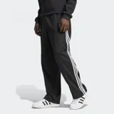 Pantalón de jogging negro Adidas Adicolor Firebird de corte holgado, con tres tiras blancas verticales a lo largo de cada pierna.
