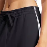Pantalón de jogging Adidas modelo Essentials French Terry Cuffed 3 Bandas, color negro con las clásicas tres tiras blancas a los lados y el logo de la marca bordado. Cuenta con cintura elástica con cordón de ajuste y puños en los tobillos.