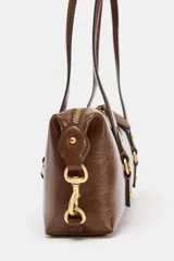 Bolso de hombro con acabado efecto craquelado en color marrón oscuro. Presenta doble asa de hombro, cierre superior con cremallera y detalles metálicos dorados en la parte frontal y laterales.
