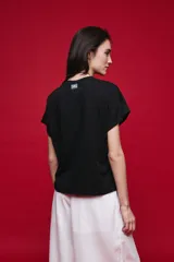 Remera negra de manga corta con cuello redondo y silueta amplia, de hombros caídos y textura suave.