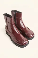 Bota corta de cuero vacuno con acabado charol brillante, diseño de punta cuadrada y suela de caucho con pequeña plataforma.