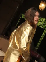 Blazer de cuero color celeste metalizado, con solapas, cierre con broches tipo tanca de madera y puños con detalle de piel sintética marrón.