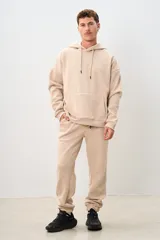 Pantalón de jogging color beige, con cintura elástica ajustable con cordón, bolsillos laterales y corte holgado.