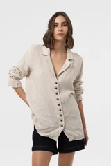 Camisa Riva de lino color beige, de calce relajado y silueta ligeramente oversized, con solapa y cierre frontal de botones.