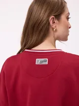 Sweater negro de corte regular con cuello redondo y puños y dobladillo acanalados con detalles de rayas grises. Presenta estampados blancos en el frente con el texto "Rusty Club" y logos de la marca.