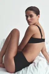 Braguita de tiro alto confeccionada en mezcla de poliamida, con diseño combinado que alterna paneles de tejido pointelle acanalado y paneles laterales de acabado satinado.