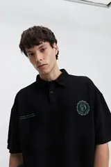 Remera polo color crema con logo bordado en el pecho, de corte amplio y mangas cortas.