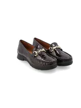 Mocasín de cuero con textura de reptil en color vino, con detalle de herraje metálico dorado en el empeine y suela de goma negra.