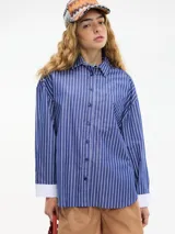 Camisa de manga larga azul con rayas verticales blancas, cuello camisero, botones en la parte delantera y bolsillo en el pecho.