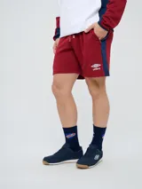 Bermuda deportiva Umbro del Club Nacional de Football, color azul marino, con cordón ajustable en la cintura, bolsillos laterales, el escudo del club en una pierna y el logo de la marca en la otra.