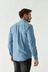 Camisa de jean manga larga con fit regular, cuello con botones, bolsillo frontal y logo bordado.