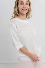 Buzo de tejido abierto color beige claro, de calce oversize con mangas 3/4 y cuello redondo. Presenta terminaciones acanaladas en puños y cintura.