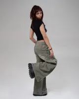 Pantalón de jean estilo wide leg con efecto de lavado desgastado en color gris verdoso. Presenta un corte holgado, tiro bajo y costuras laterales reforzadas.