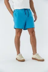 Short de baño liso con cintura elástica y cordón de ajuste. Cuenta con dos bolsillos laterales, un bolsillo posterior y un aplique de logo en goma en la pierna.