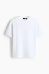 Remera blanca de manga corta, cuello redondo ribeteado y corte relajado con hombros caídos. Fabricada en punto liviano con fibra COOLMAX.
