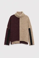 Polera de cuello alto confeccionada en lana, con diseño bicolor en tonos bordó y beige. Presenta mangas largas con franjas negras laterales y un corte holgado con ruedo asimétrico.