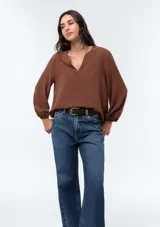 Blusa de viscosa color marrón con escote en V, mangas tres cuartos con puños elásticos y corte holgado.