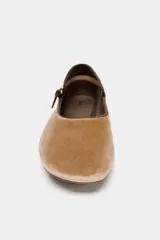 Zapato tipo bailarina de efecto terciopelo en color tostado, con tira fina ajustable con hebilla en el empeine y punta redonda.