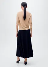 Jersey de punto fino color beige claro, con escote en V y mangas largas.