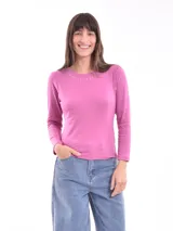 Remera de manga larga color fucsia con cuello redondo y detalle de pequeñas tachas plateadas alrededor del cuello.