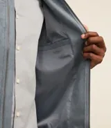 Chaqueta bomber azul marino lisa, con cierre frontal, cuello redondo y bolsillos laterales.