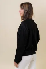 Buzo de manga larga color verde claro, con cuello redondo y calce relajado.