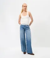 Pantalón wide leg de tiro bajo confeccionado en jean de algodón, con diseño amplio y aplicación de tachas y ojalillos metálicos a lo largo de los laterales.