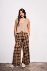 Pantalón de tiro medio, corte recto y pierna ancha, con estampado de cuadros escoceses en tonos marrón, beige y negro.