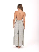 Vestido largo negro con diseño cut-out en la cintura y detalle de abertura circular en el pecho con cordón ajustable. Presenta breteles finos y falda amplia con tajo frontal.