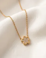 Collar de cadena fina con dije en forma de flor con incrustaciones de circonias, con baño de oro.