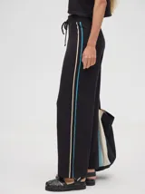 Pantalón de algodón color rojo, de corte holgado y pierna ancha, con pretina elástica y rayas bicolores al costado.